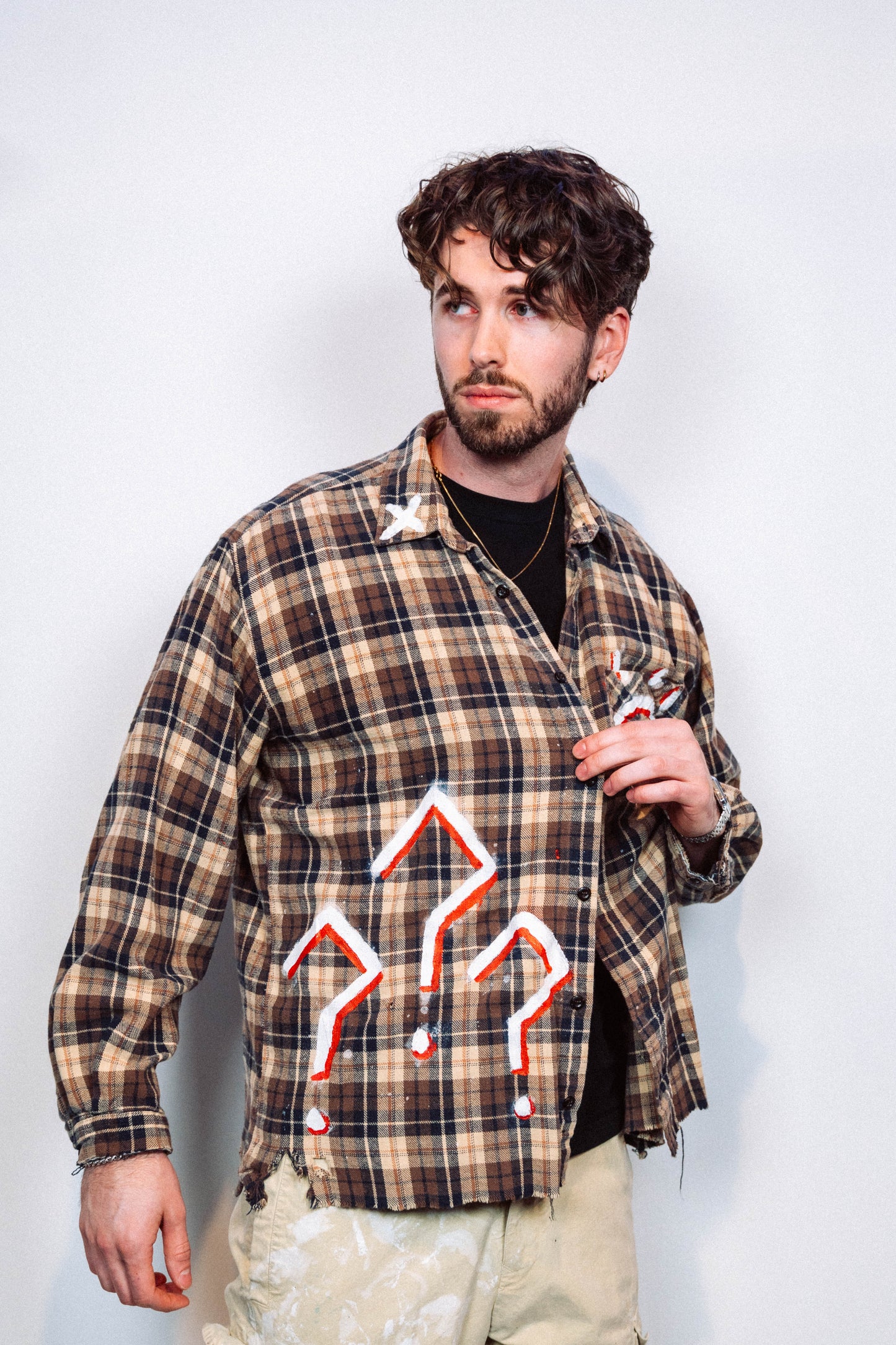 Man wearing a 1 of 1 Hand Painted plaid flannel from luxury wearable art brand "Where Is Up" on a plain background