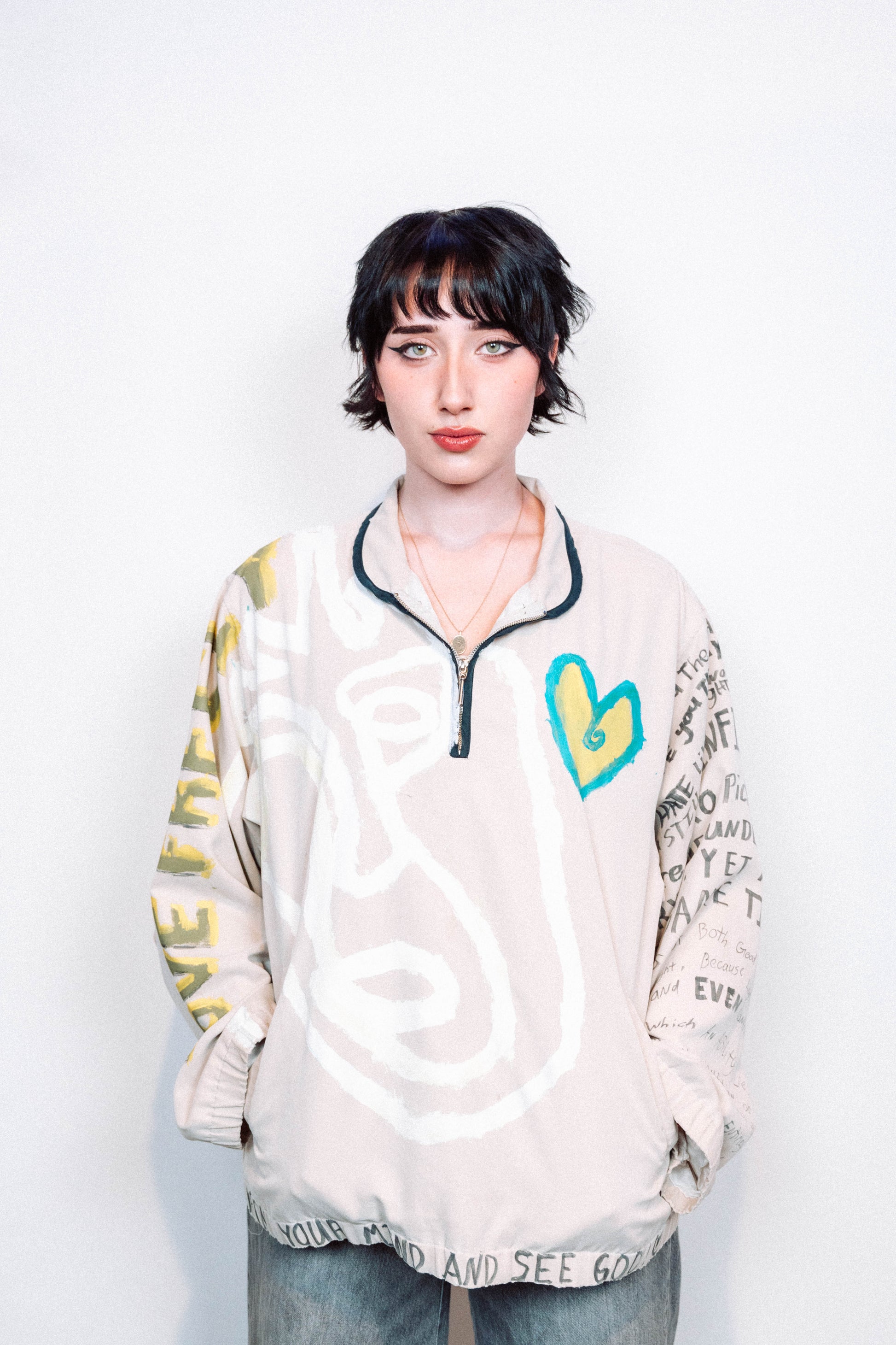 Person Wearing a creme colored 1 of 1 hand painted quarter zip from the brand Where Is Up?