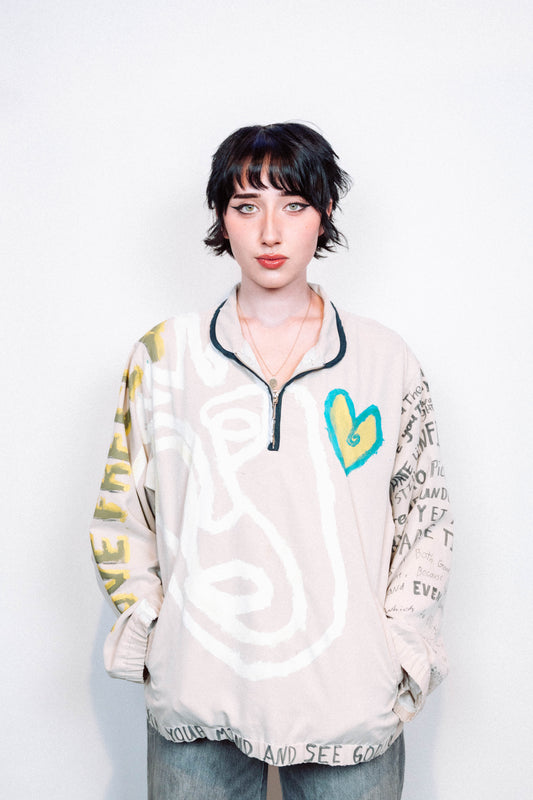 Person Wearing a creme colored 1 of 1 hand painted quarter zip from the brand Where Is Up?