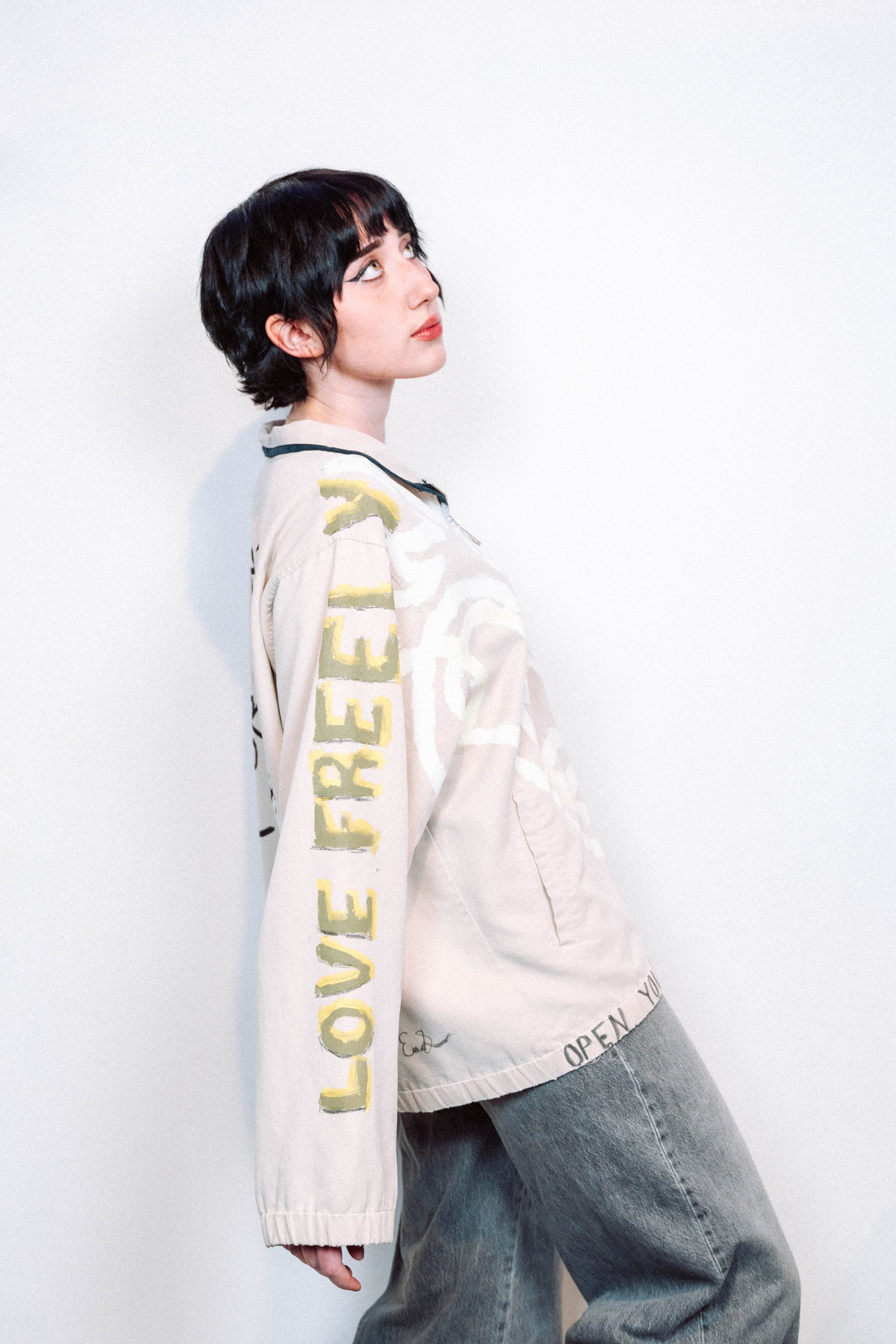 Person Wearing a creme colored 1 of 1 hand painted quarter zip from the brand Where Is Up?
