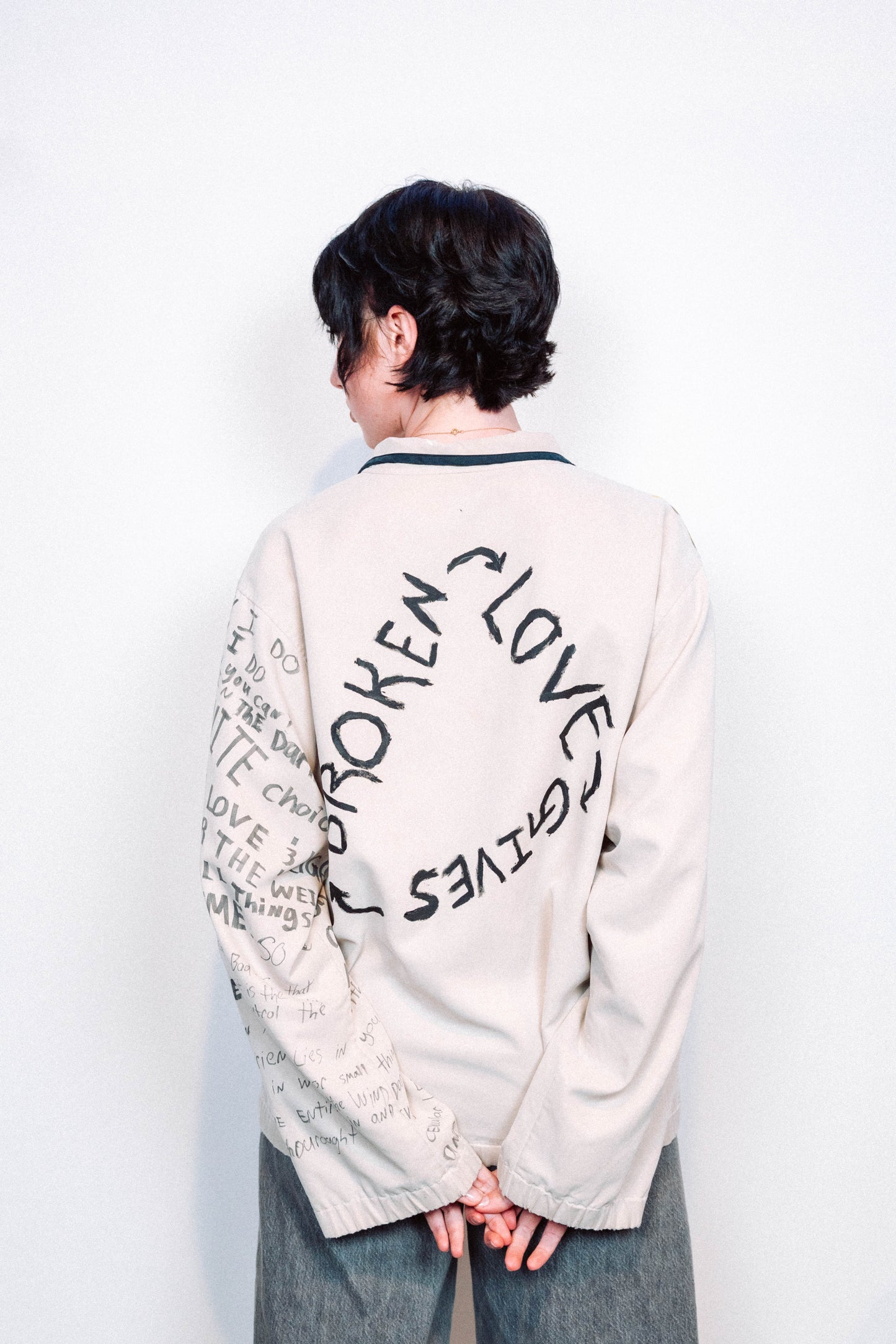 Person Wearing a creme colored 1 of 1 hand painted quarter zip from the brand Where Is Up?