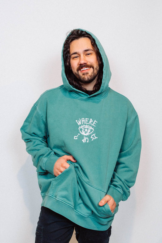 Man wearing a teal hoodie with a logo on a white background