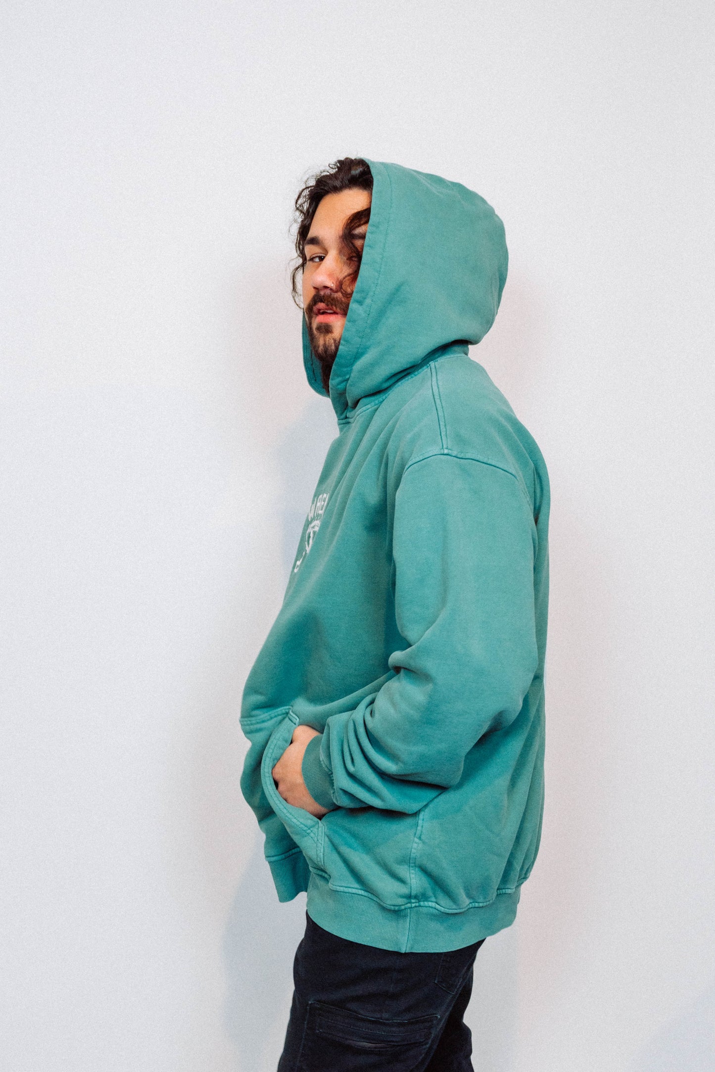 Person wearing a teal hoodie against a white background