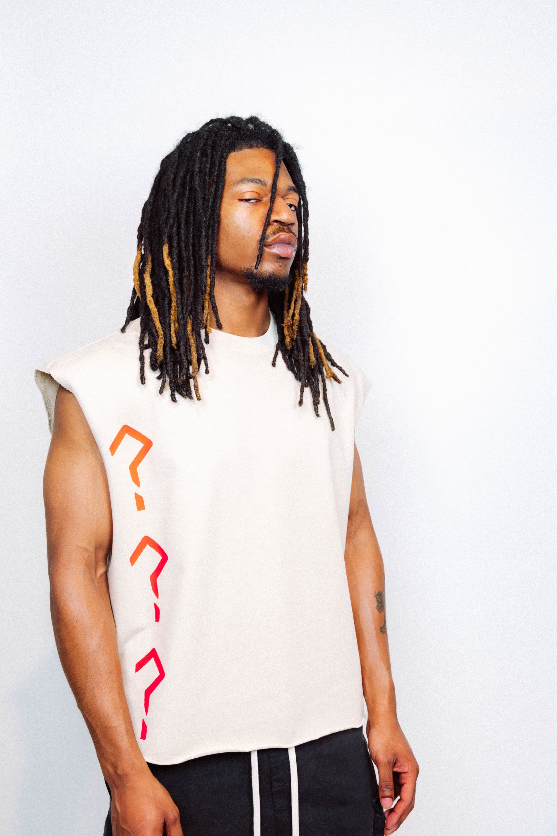Man wearing limited edition "REVIVAL" Cut -off tee in front of a white background
