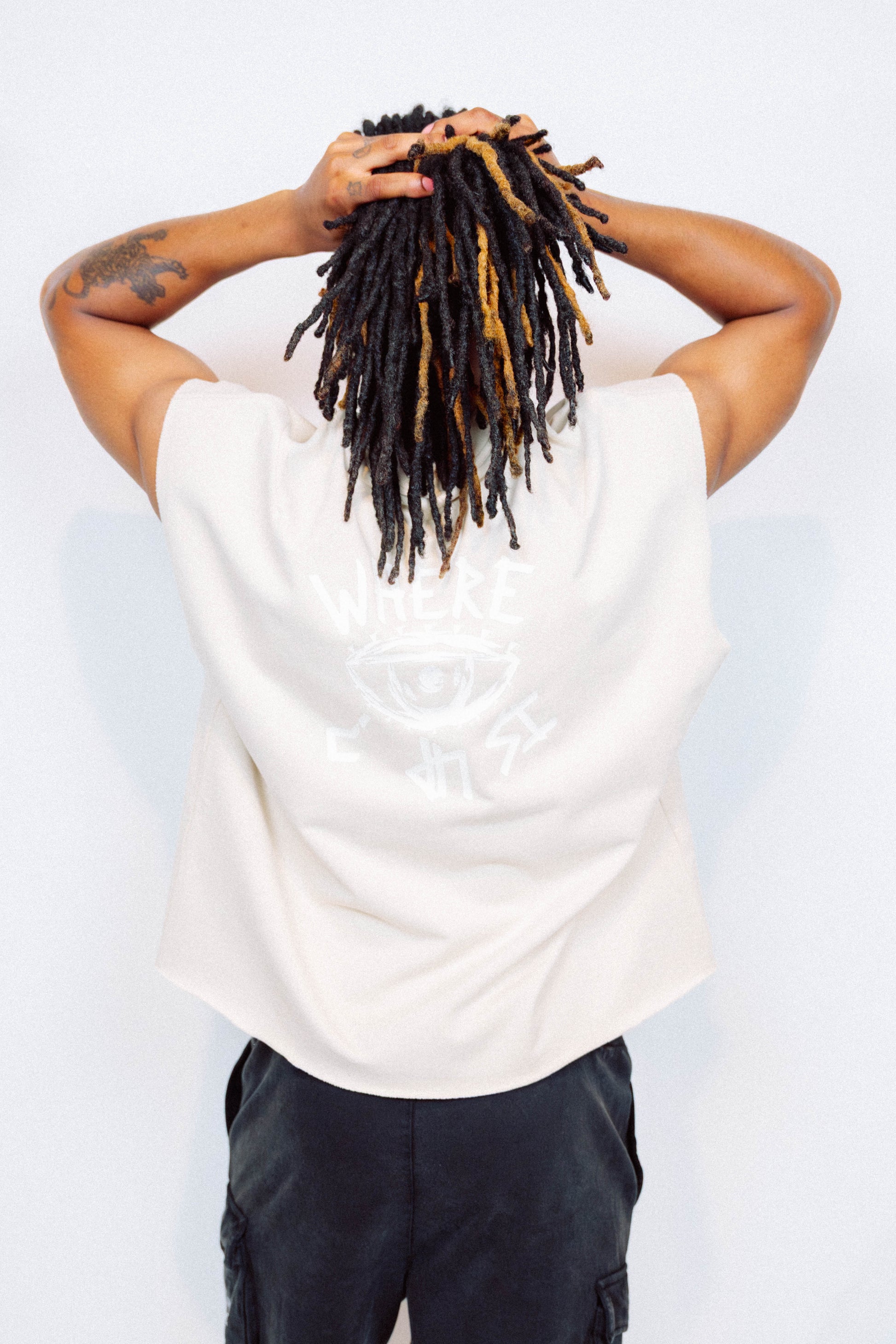 Man wearing limited edition "REVIVAL" Cut -off tee in front of a white background
