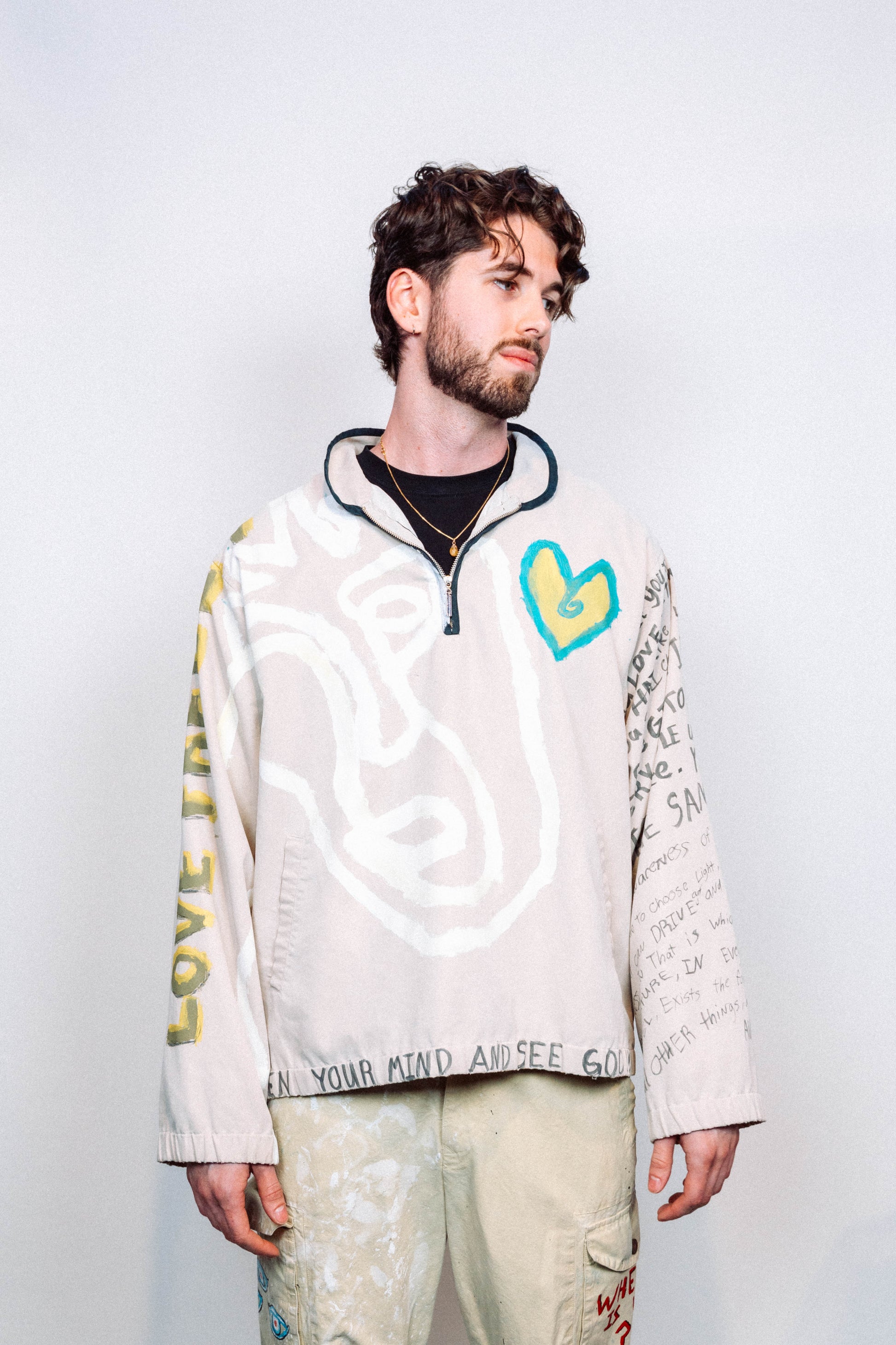 Person Wearing a creme colored 1 of 1 hand painted quarter zip from the brand Where Is Up?