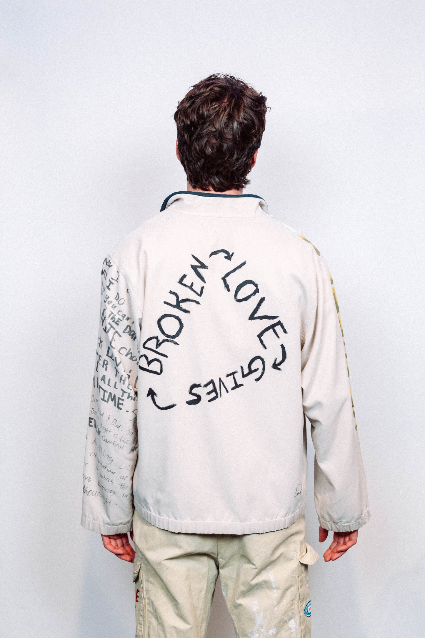 Person Wearing a creme colored 1 of 1 hand painted quarter zip from the brand Where Is Up?