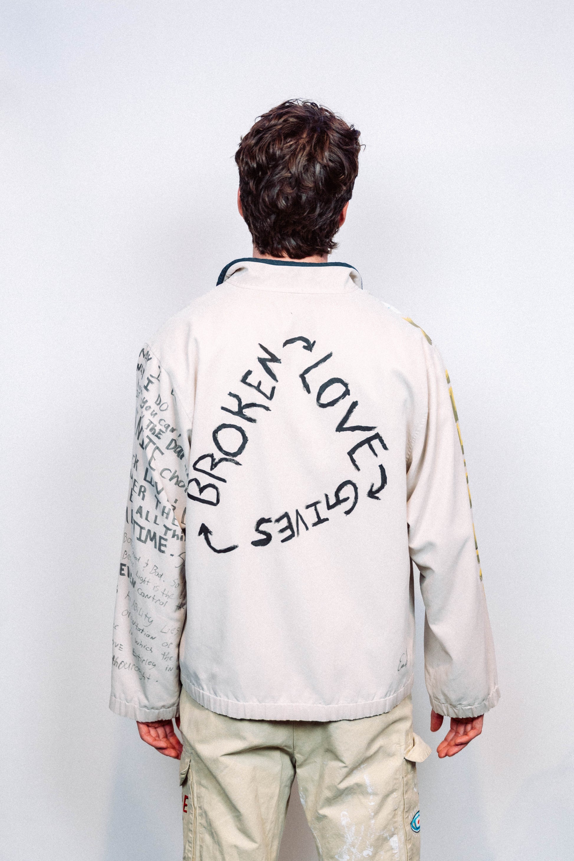 Person Wearing a creme colored 1 of 1 hand painted quarter zip from the brand Where Is Up?