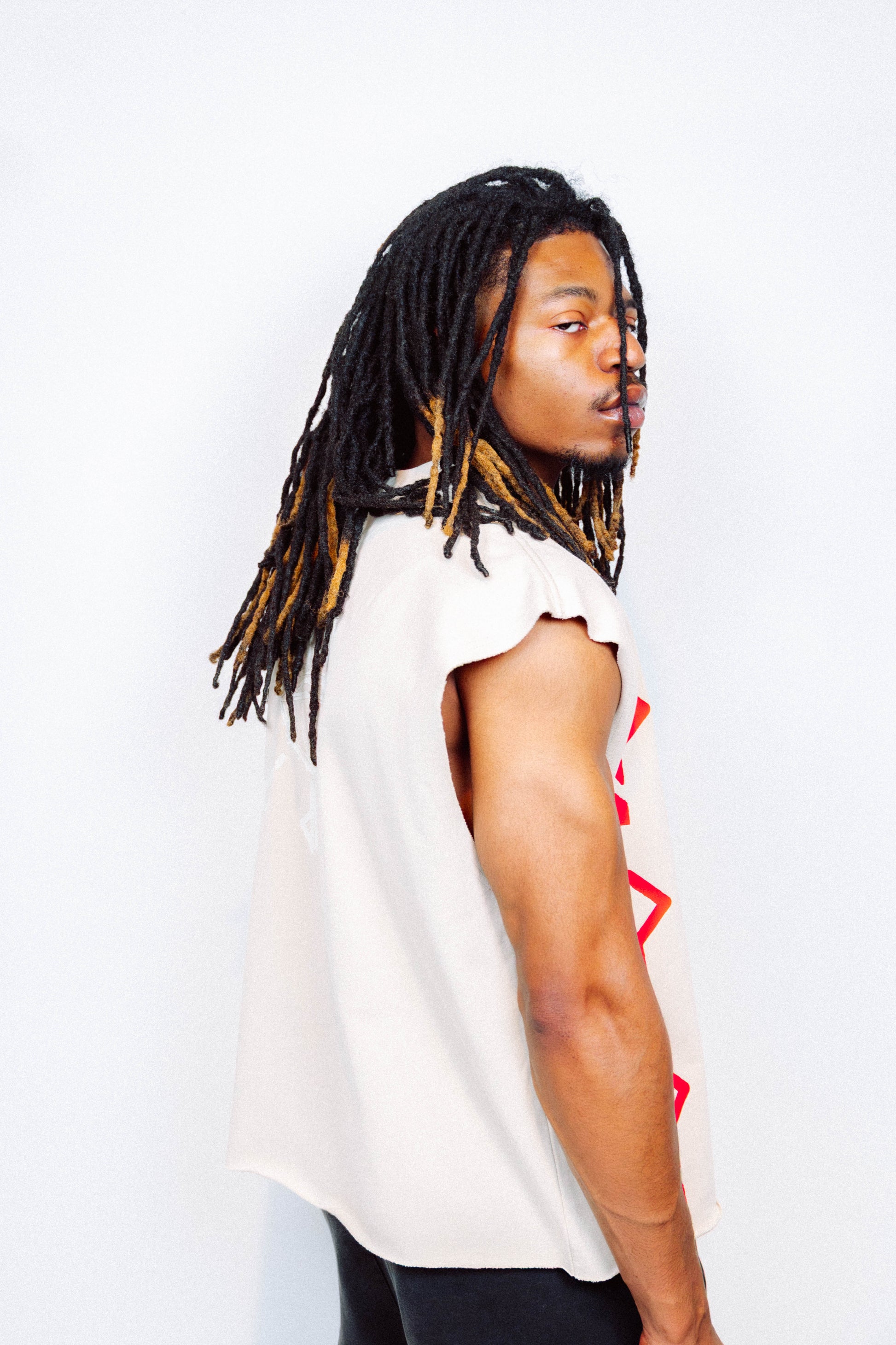 Man wearing limited edition "REVIVAL" Cut -off tee in front of a white background