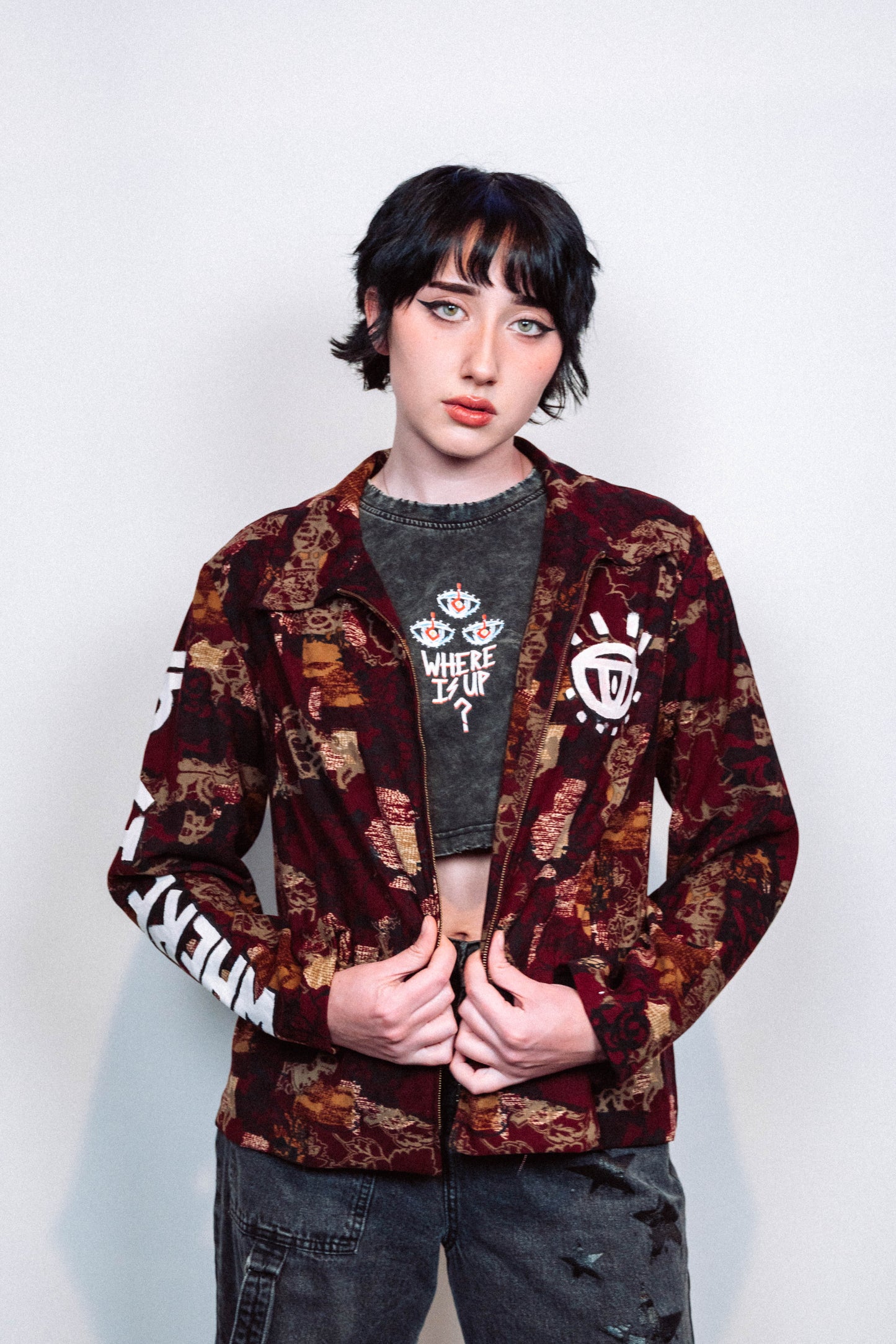 girl wearing a 1 of 1 hand painted pattern jacket with white paint in front of a white background
