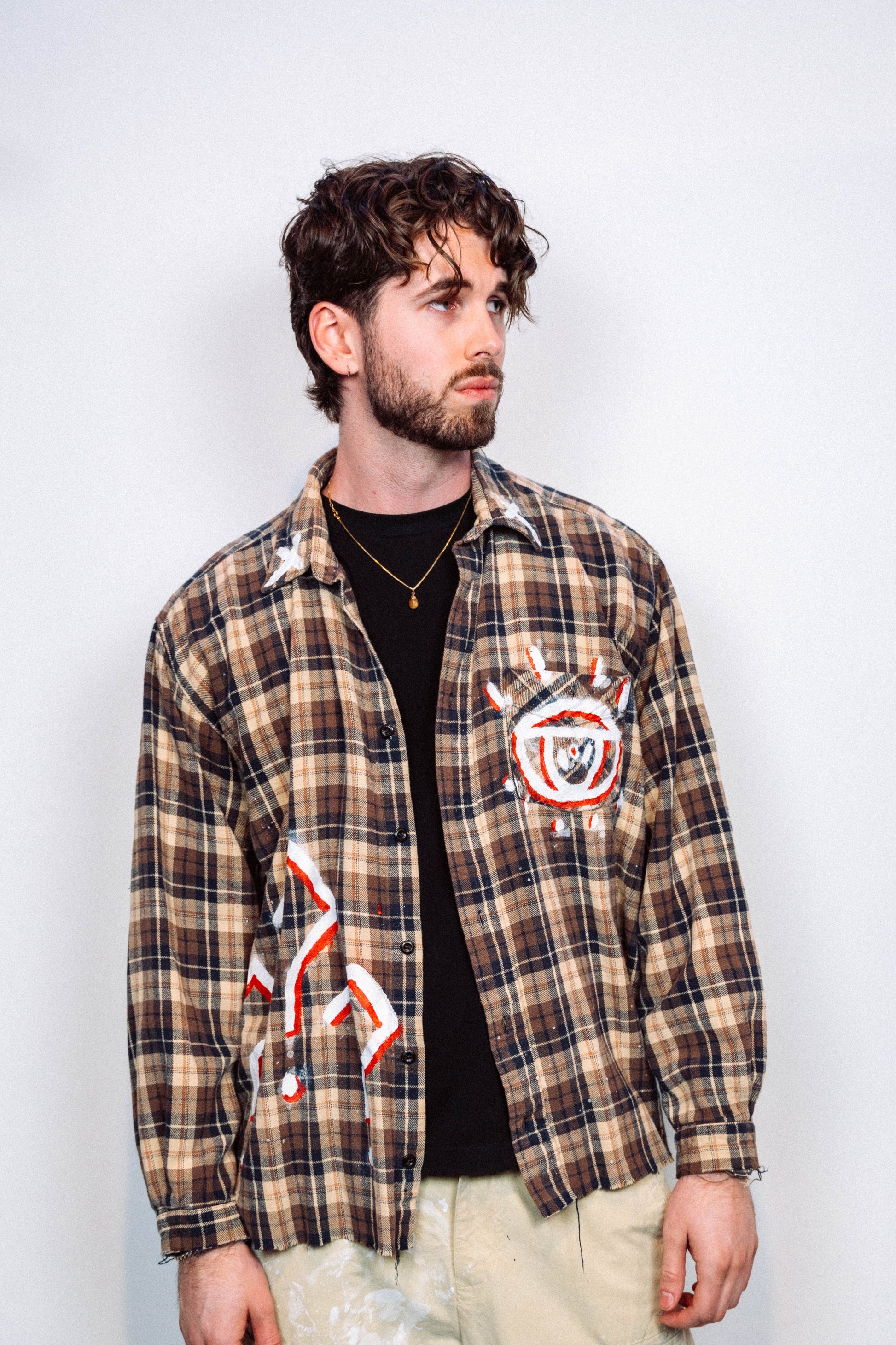 Man wearing a 1 of 1 Hand Painted plaid flannel from luxury wearable art brand "Where Is Up" on a plain background 