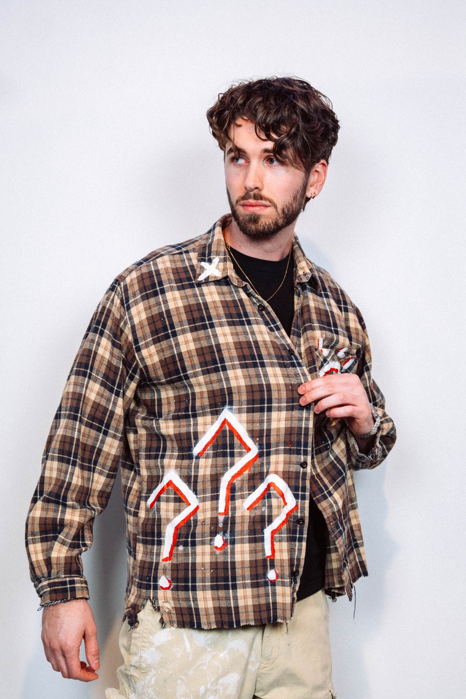 Man wearing a 1 of 1 Hand Painted plaid flannel from luxury wearable art brand "Where Is Up" on a plain background 