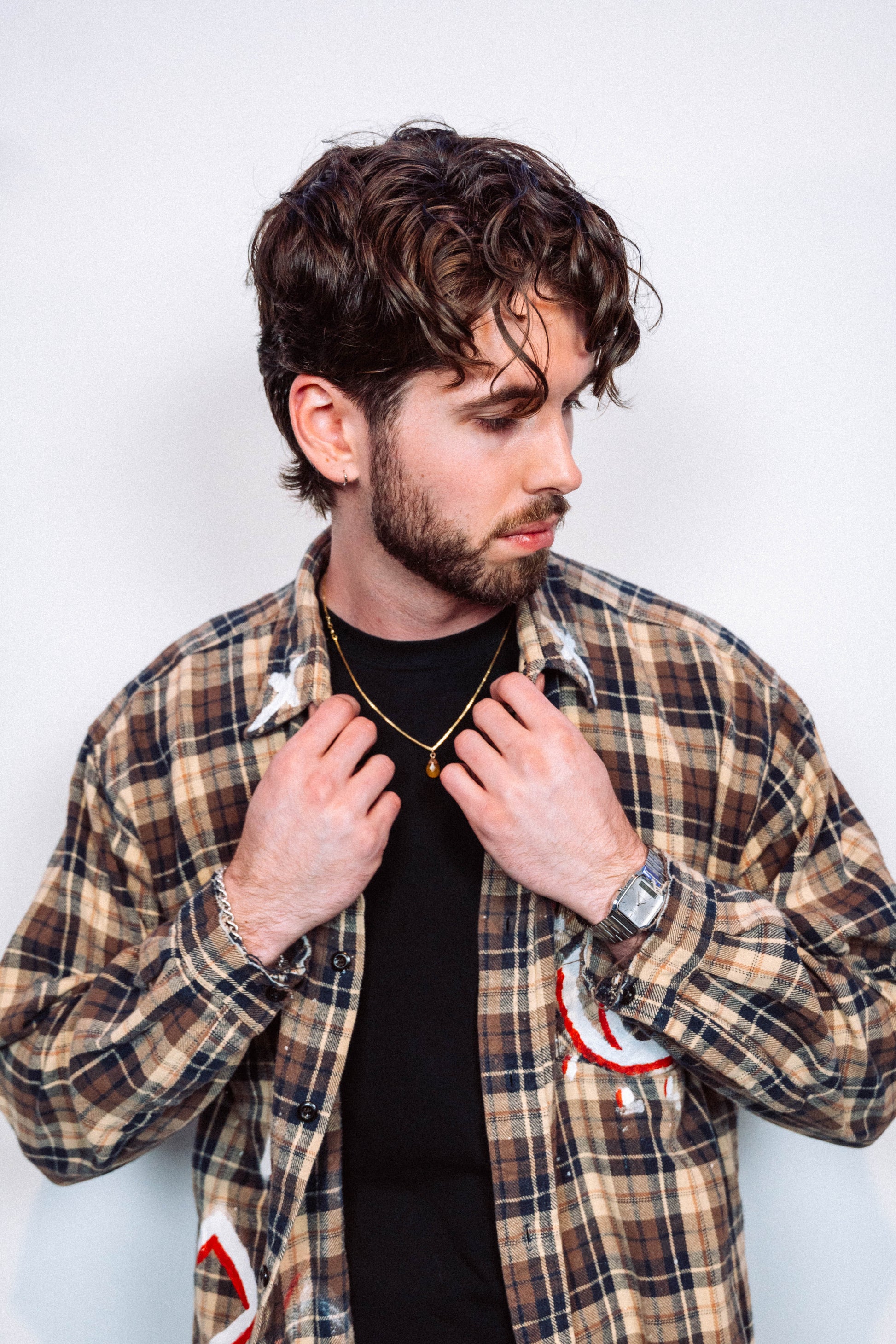 Man wearing a 1 of 1 Hand Painted plaid flannel from luxury wearable art brand "Where Is Up" on a plain background 