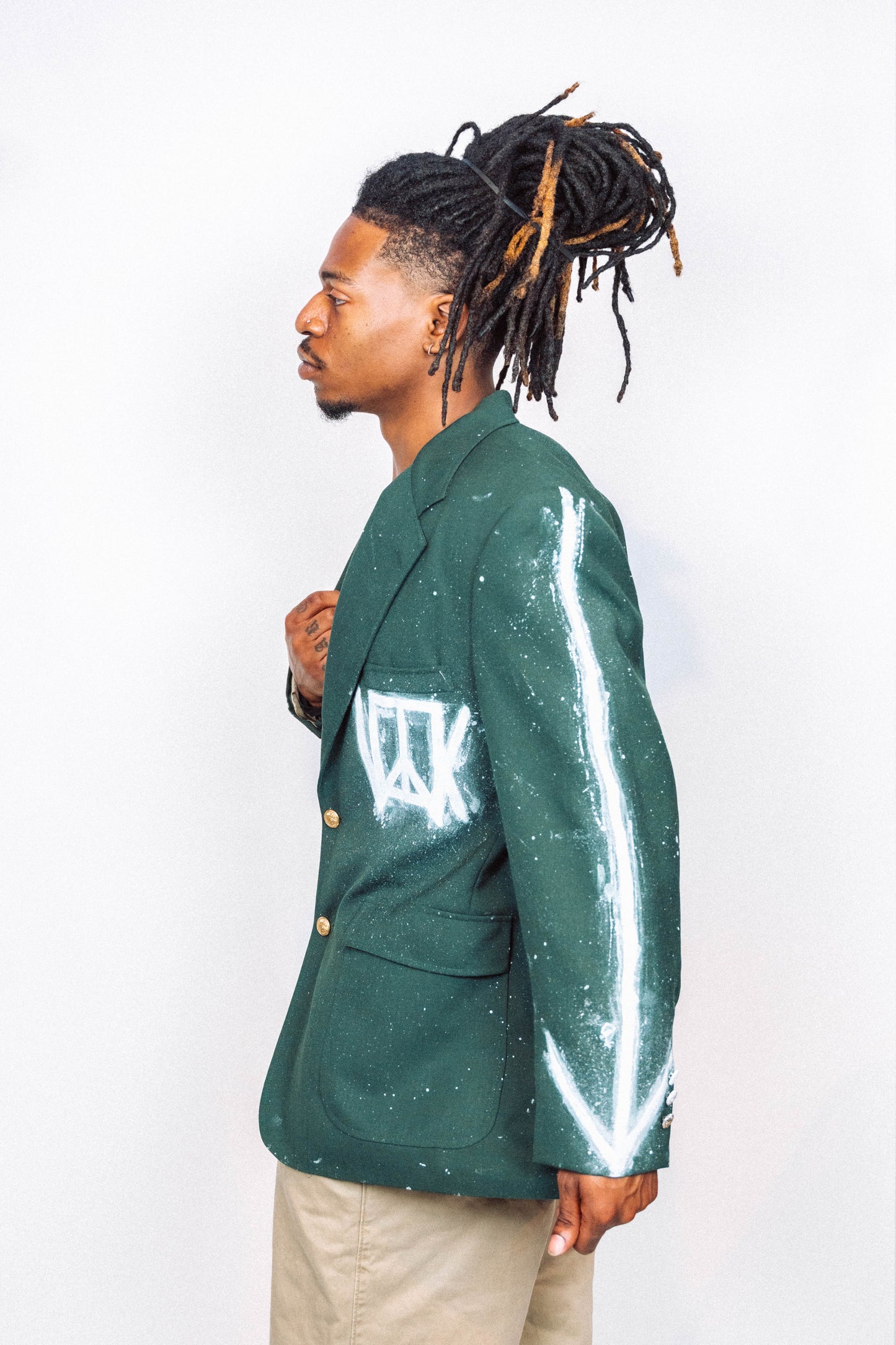 Man wearing a 1 of 1 Hand Painted and spray painted vintage green suit blazer in front of a white background.