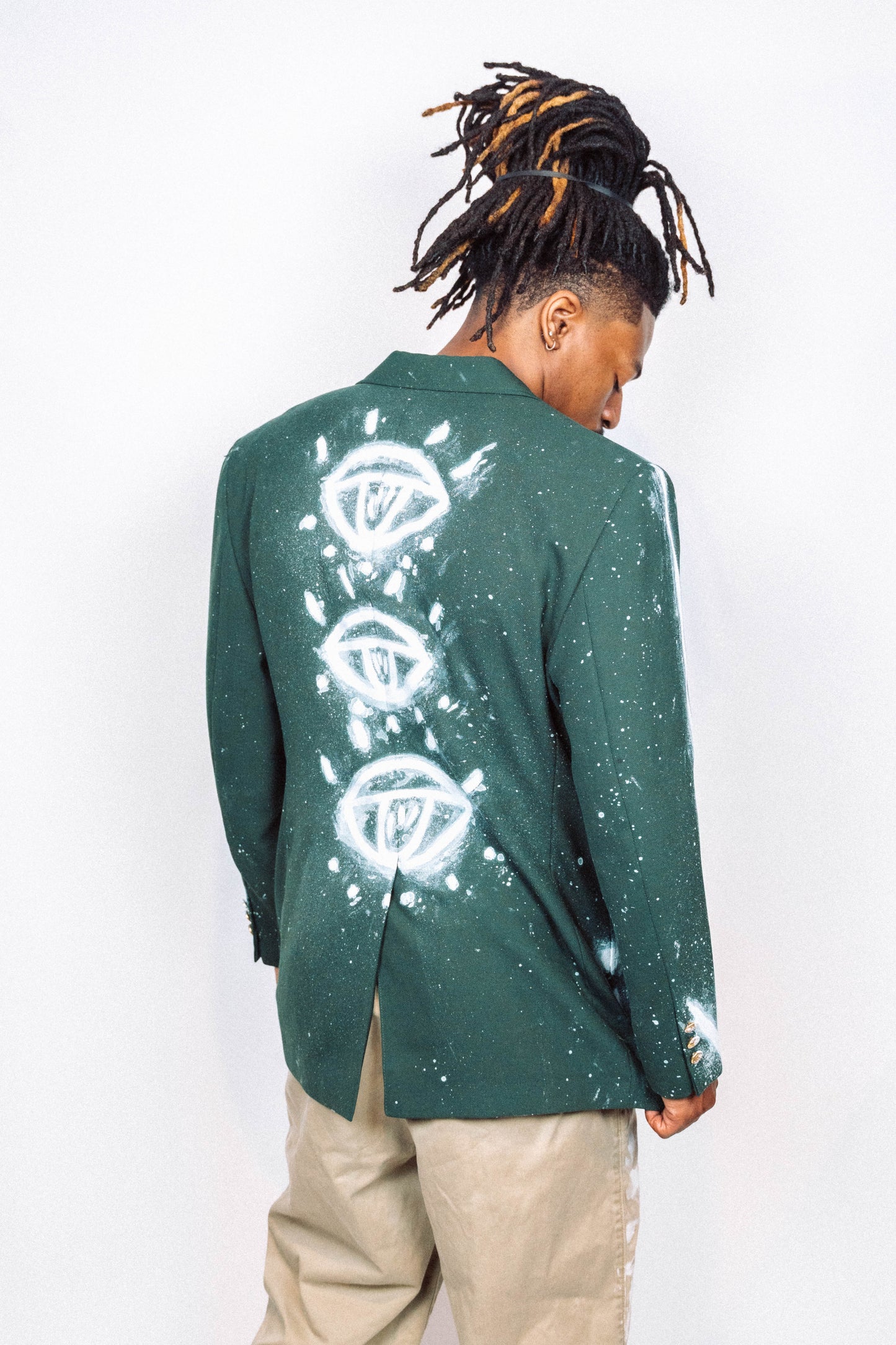 Man wearing a 1 of 1 Hand Painted and spray painted vintage green suit blazer in front of a white background.